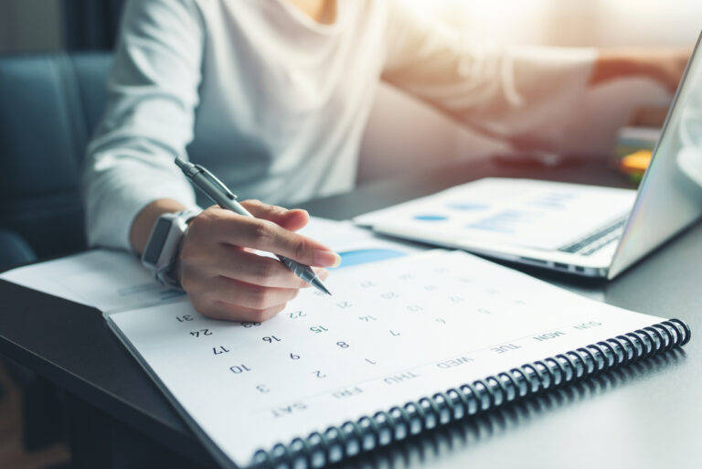 Person planning at laptop with calendar