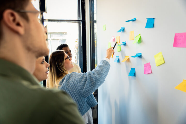Team planning content on whiteboard with sticky notes